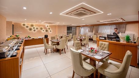 A view of a dining or event space within the hotel, showing table arrangements - SK Lords Inn Ahmedabad