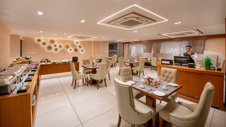 A view of a dining or event space within the hotel, showing table arrangements - SK Lords Inn Ahmedabad