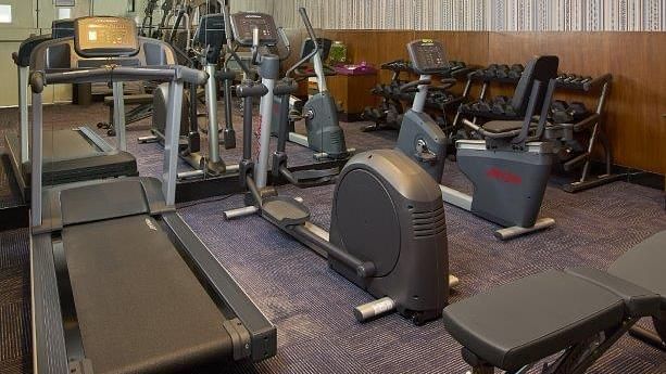 A gym with weightlifting equipment, including dumbbells, barbells, and weight plates.
