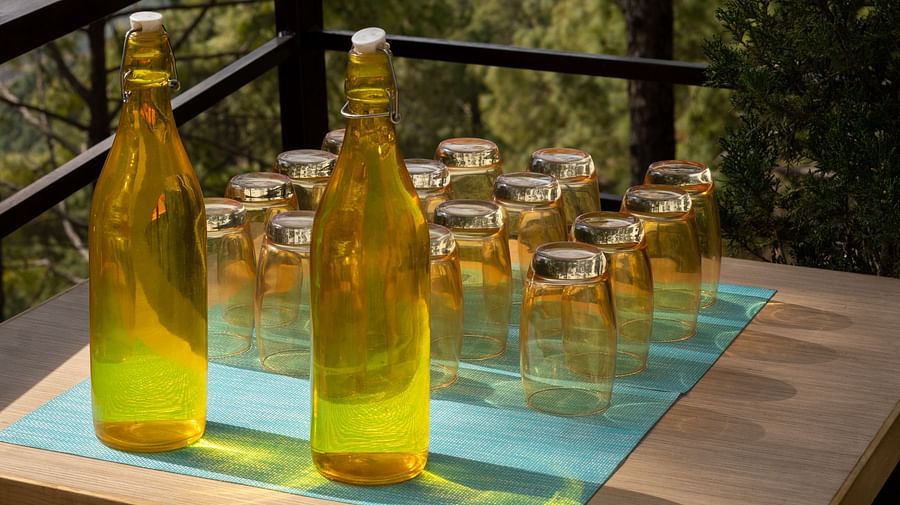 Two glass bottles and glasses arranged neatly on a table at BluSalzz Escapade Resort, Lansdowne