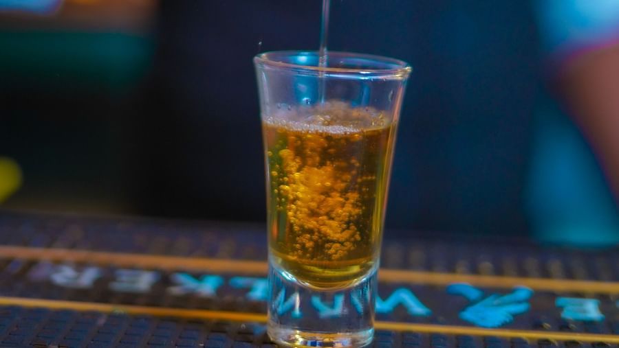 An image of a person pouring drink on a glass at Themis Barbecue House, Panipat