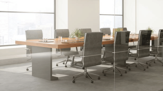 Glass-walled conference room with long table and office chairs.
