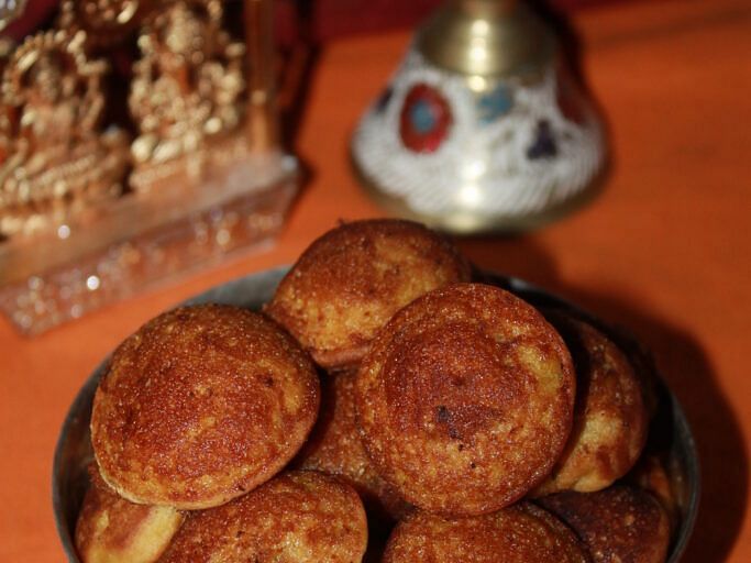 Close-up of traditional Indian sweet dumplings served in a brass vessel.