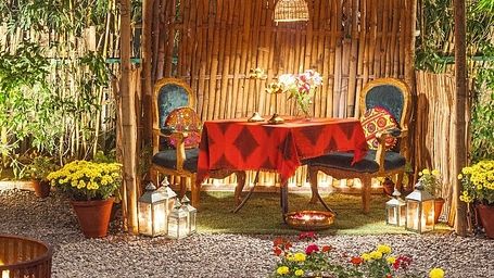 Gazebo setup at Karma Chalets with cushions, low seating, and flowers arranged on the ground.