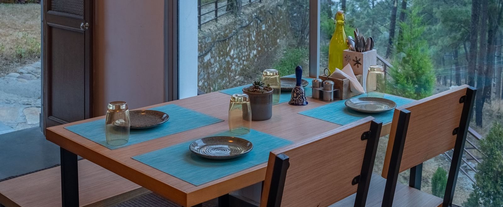 A restaurant with a large glass window beside it, offering a view of the interior dining area at BluSalzz Escapade Resort, Lansdowne