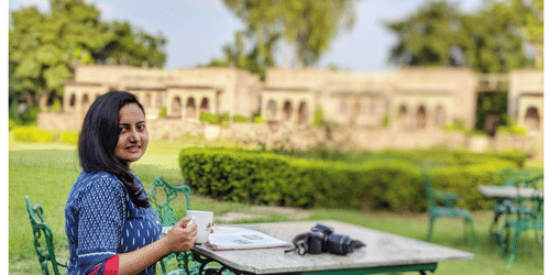 a woman sits outside on the lawn