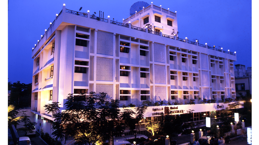 Evening view of the multi-storey Hotel Pandian exterior building brightly illuminated by outdoor lights - Hotel Pandian
