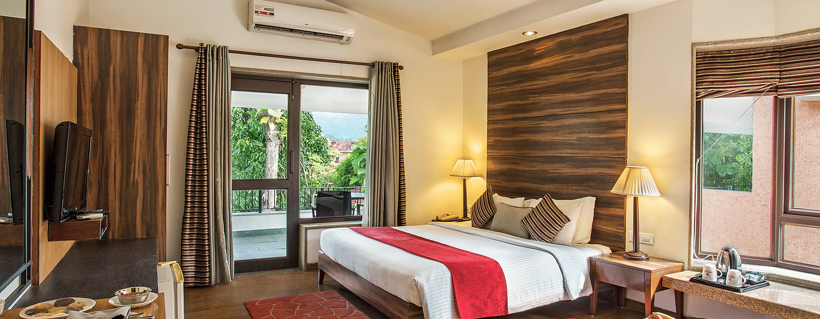 Hotel room featuring a cozy bed, wall-mounted TV, and a view from the window.