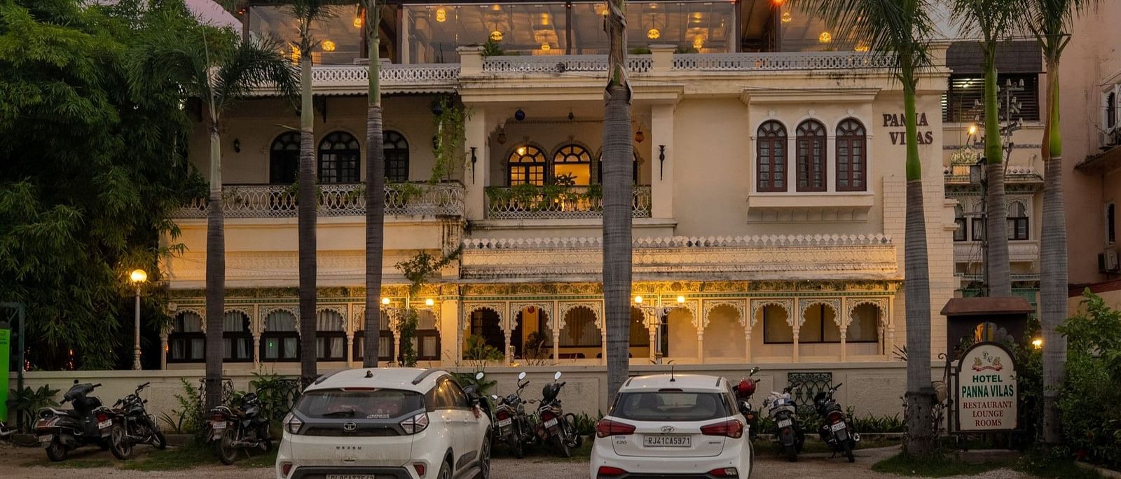 A facade view of Panna Vilas Palace, featuring cars parked infront the building| Panna Vilas Udaipur | Panna Vilas Udaipur