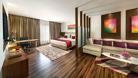 image of a bedroom with a living space at Grand Kakinada by GRT Hotels