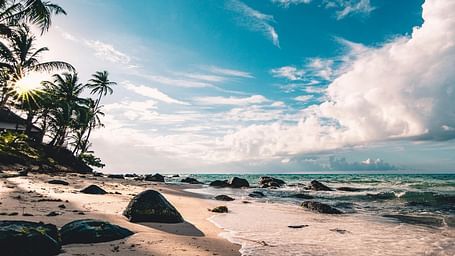 Beach view with gentle, pleasant waves and a partially cloudy sky