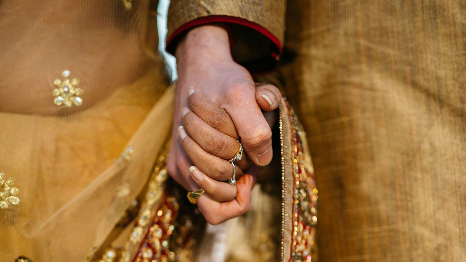 Front view of a couple holding hands in traditional attire.