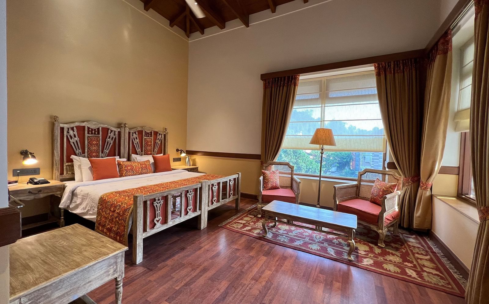  A comfortable Superior Lake Facing Room at Fishermen's Lodge, Bhimtal, featuring a wide open window with stunning views of the lake and surroundings.