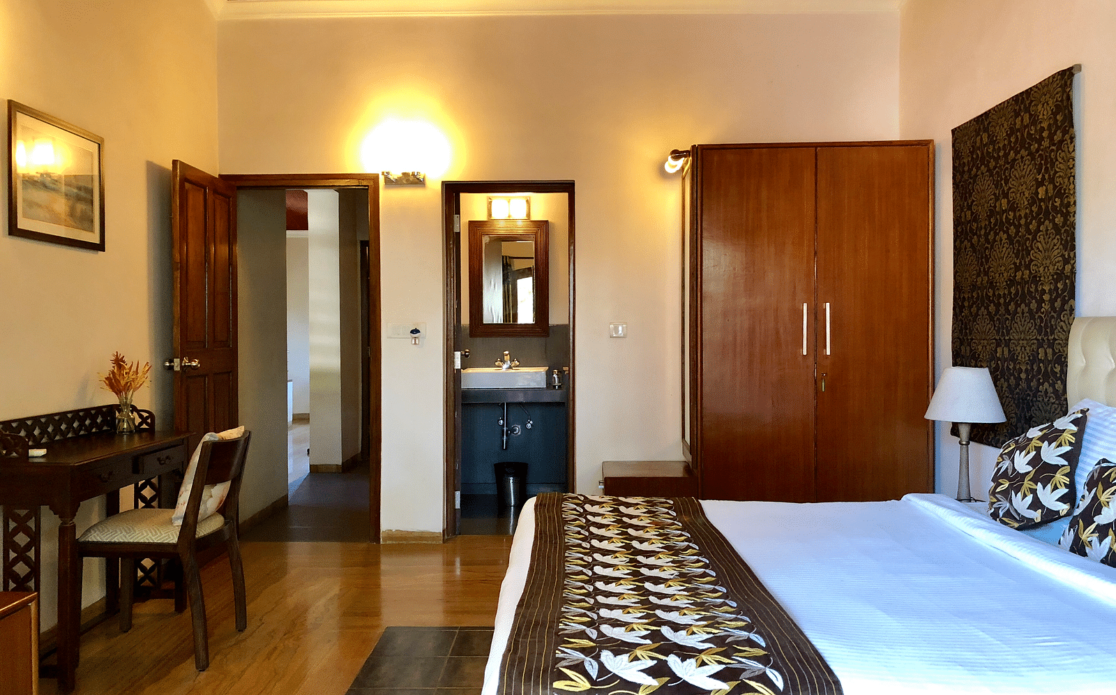 Room featuring a double bed a work desk, a wardrobe and a bathroom
