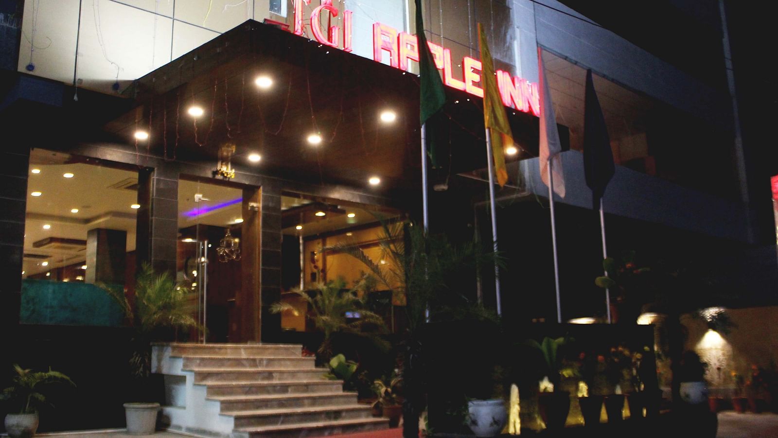 A view of the hotel from the outside illuminated by warm yellow lighting  - TGI Apple Inn, Jaipur 