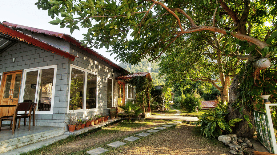 A walkway with stone laid garden beside at Neer Ganga Resorts during daytime
