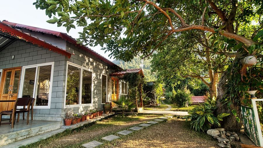 a walkway with stone laid garden beside at Neer Ganga Resorts during daytime