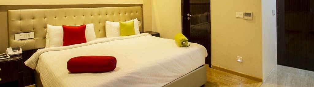 The room of the suite with bed and pillows and blosters on in at Art Boutique Hotel, Hyderabad