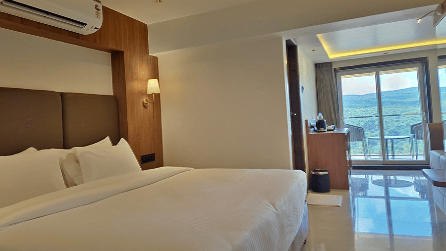 Bedroom with a double bed, air conditioner, wooden furnishings, and balcony access