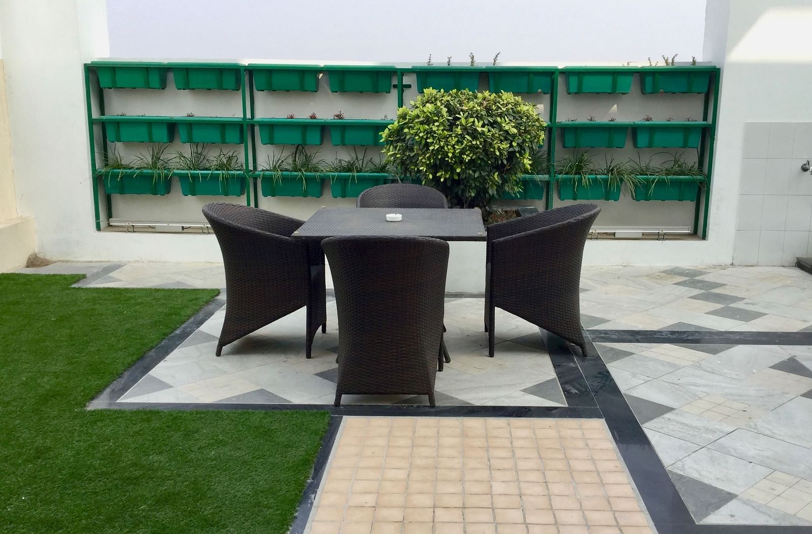 A beautiful open terrace featuring a common seating area with three chairs surrounding a table - Ramada by Wyndham, Ghaziabad, Vasundhara