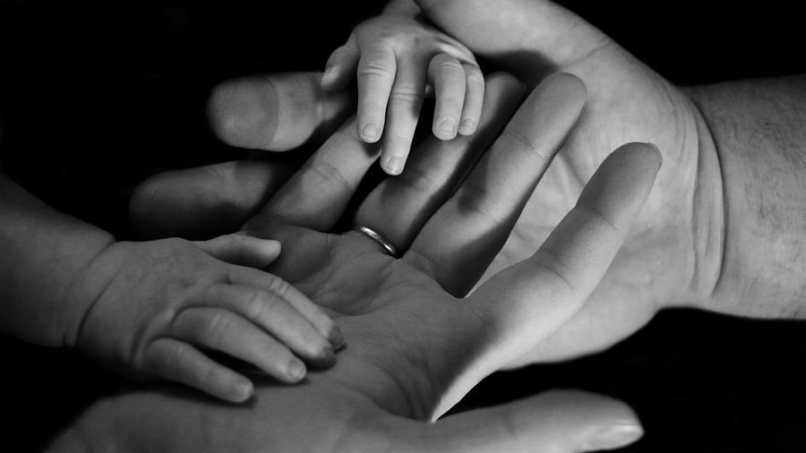 A couple s hand with a baby hand in a black and white photo