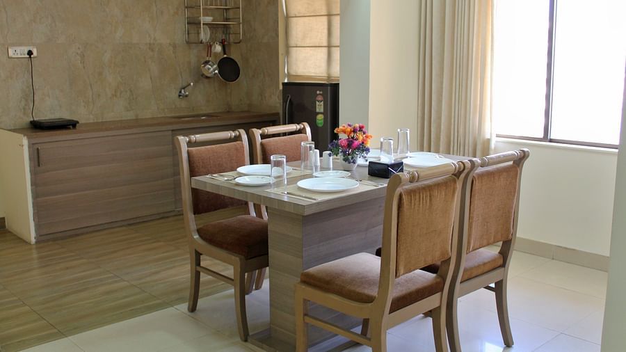 A back view of a rectangular dining table with four brown chairs around it