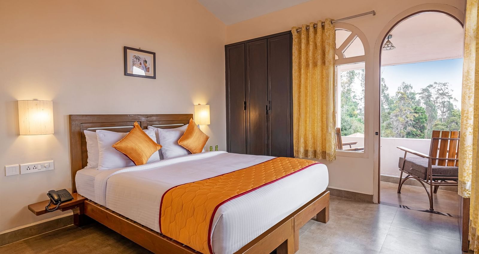 Cozy bedroom with a queen-size bed and orange accents, featuring large windows and a balcony view.