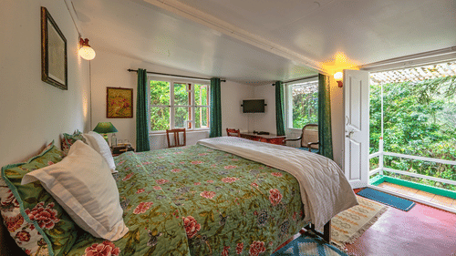 Camphor room at Wallwood Garden - 19th Century, Coonoor with a double bed, floral quilt, garden-facing windows and private sit-out.