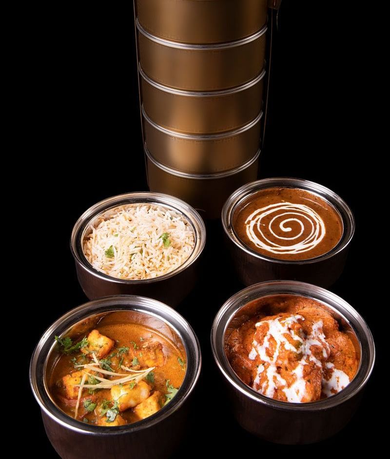 image of a tiffin served at  The Claridges New Delhi with delicious food items