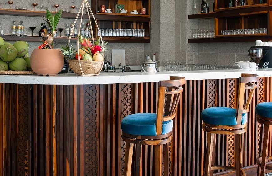A bar counter at our restaurant with blue coloured high chairs placed in front - Alibu Resort Nha Trang