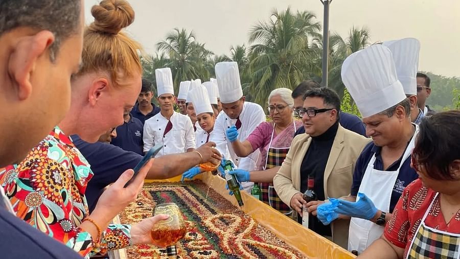 An image of chefs and many guests decorating cake with dry fruits - Cloud9 Sarovar Premiere, Palolem Goa