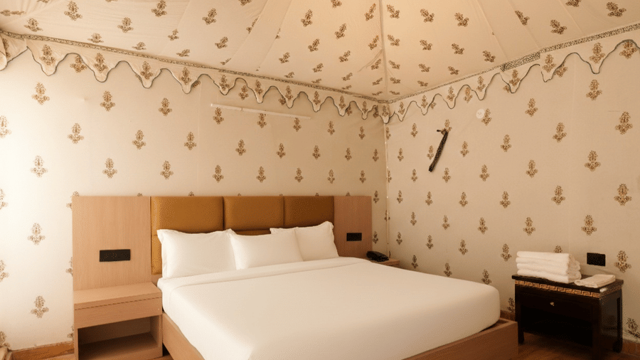 A room at Grassfield Riviera Resort, featuring a large bed, bedspreads, pillows, and a table.