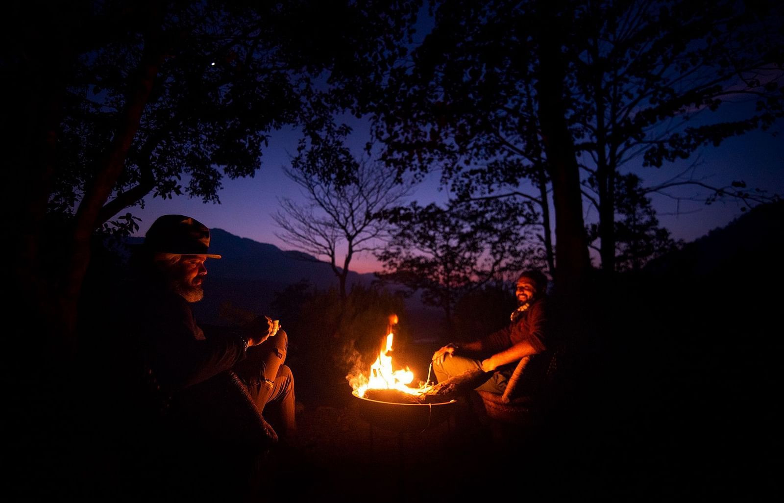 people sitting around a bonfire in the evening - The Jamoon, Corbett