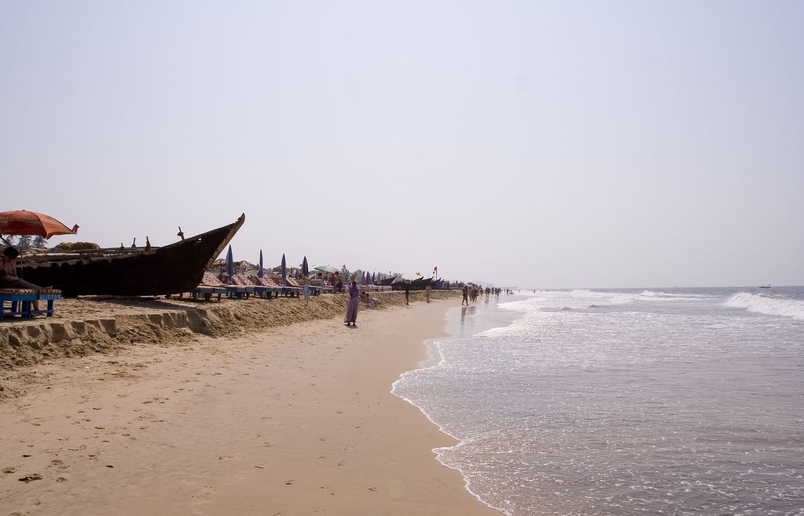 Beach during broad daylight featuring a boat at the shore