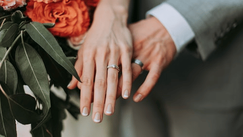 bride and groom showing off their rings