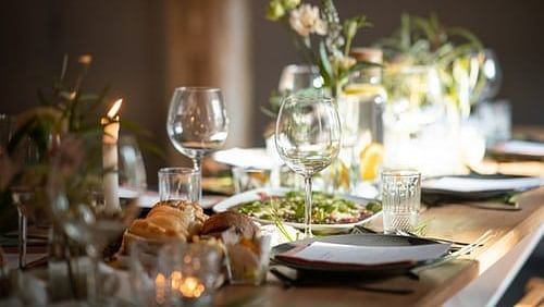 a table set with wine glasses and flowers for an event
