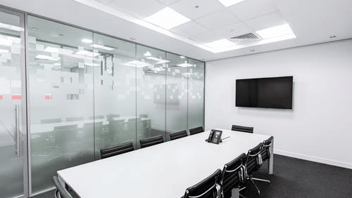  A meeting room with an elongated table, chairs, a television, and a transparent door.