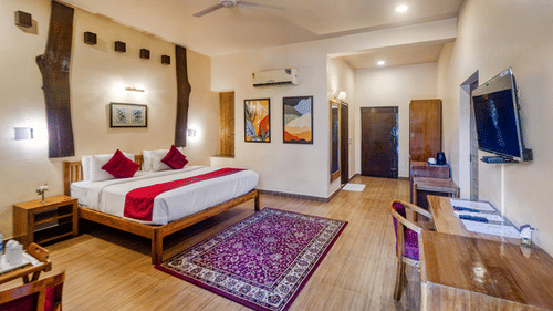 Luxurious resort suite with a king-size bed, seating area, and ample space.