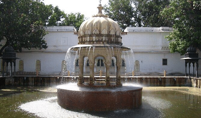 A fountain with a domed structure in the center of a pool. 
