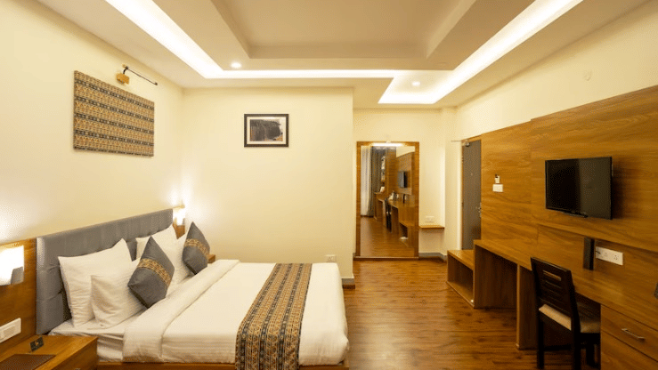 Well-appointed Deluxe Room at Voyage The Royal Retreat with modern comforts and tasteful wooden accents.