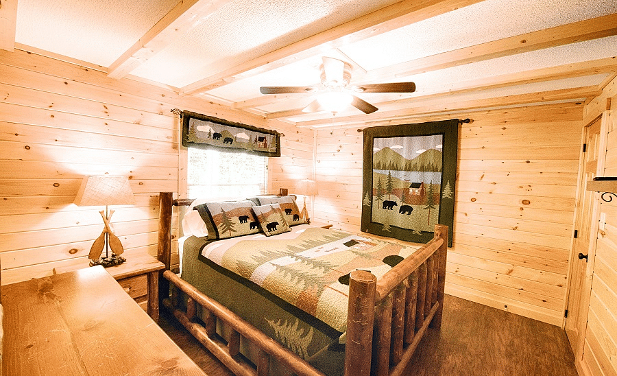 corner view of a bedroom with a double bed along with a brightly lit lamp kept on the bed side tablev