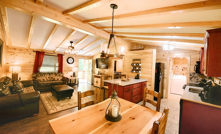 corner view image of the dining area also featuring the kitchen and the common seating area with a wooden ceiling - Historic Tapoco Lodge
