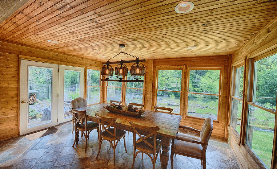 a beautiful dining area surrounded by huge glass windows with views of the lush green surroundings - Historic Tapoco Lodge