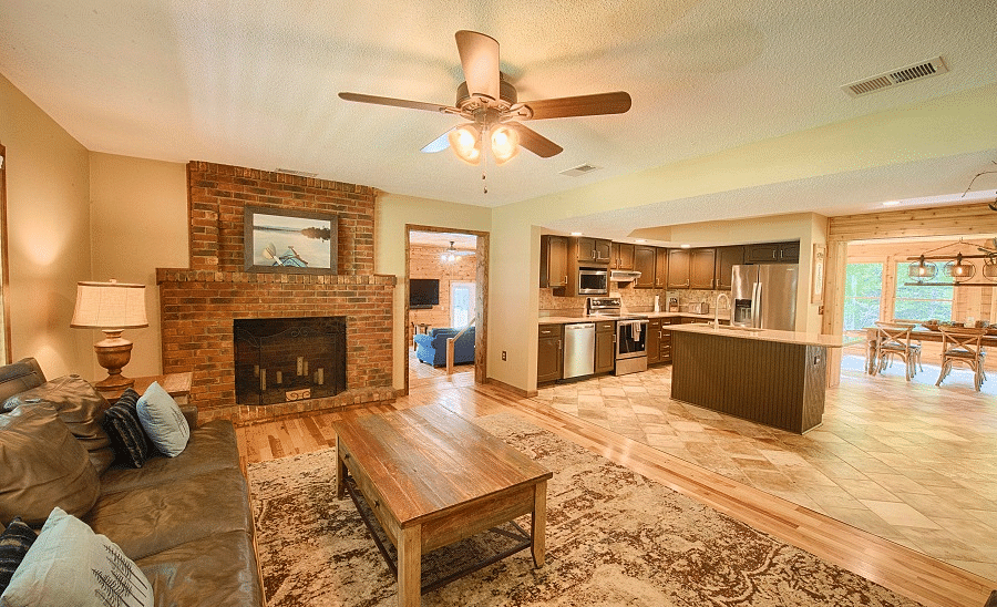 the living room featuring a fireplace along with a common seating area extending to the kitchen and a dining area - Historic Tapoco Lodge