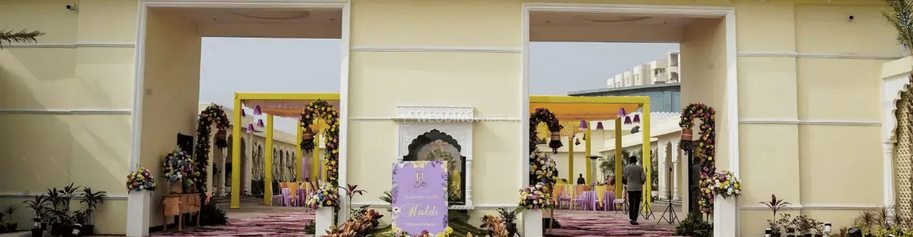 The entrance of a building with two doors and potted plants outside at Beelwa Palace, Jaipur.