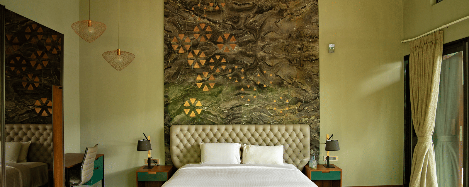 A bedroom at Stanley Revelation with a double bed, a tall tufted headboard, and decorative wall art.