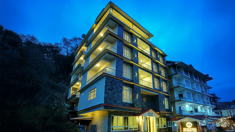 Facade of Voyage The Aryan Regency with warm sunset sky, illuminated building exterior
