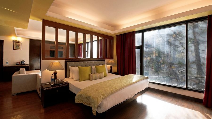 a view of a bed in Suite decked with a bed with yellow duvet at Mastiff Grand, Manali