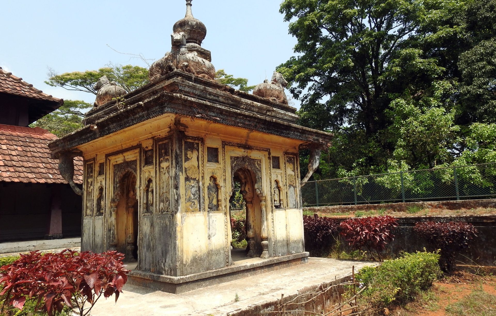 Ancient Nalknad Palace with a dome, surrounded by nature.