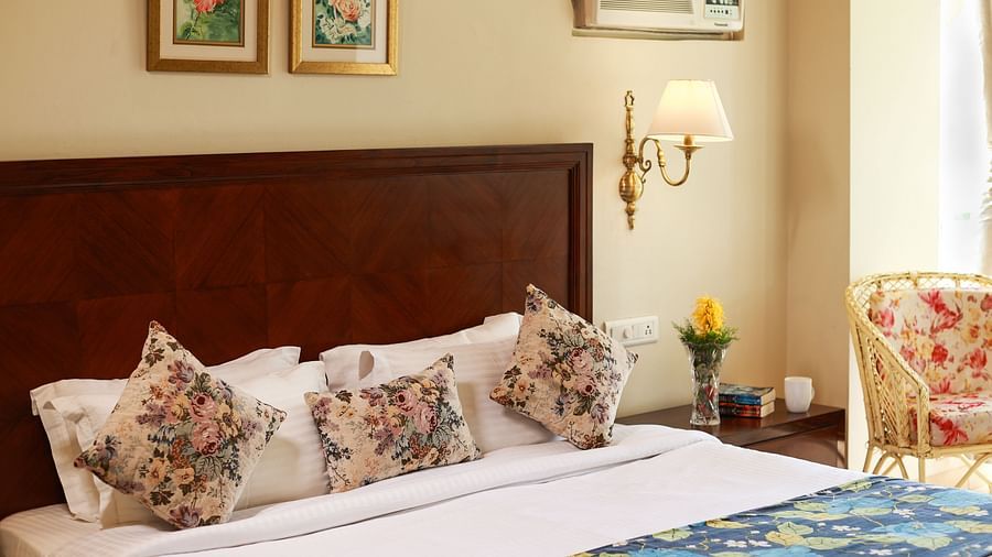 Closer view of a beautifully tucked bed with soft lines and pillows along with bedside lamps - Lamrin Norwood Green, Palampur2